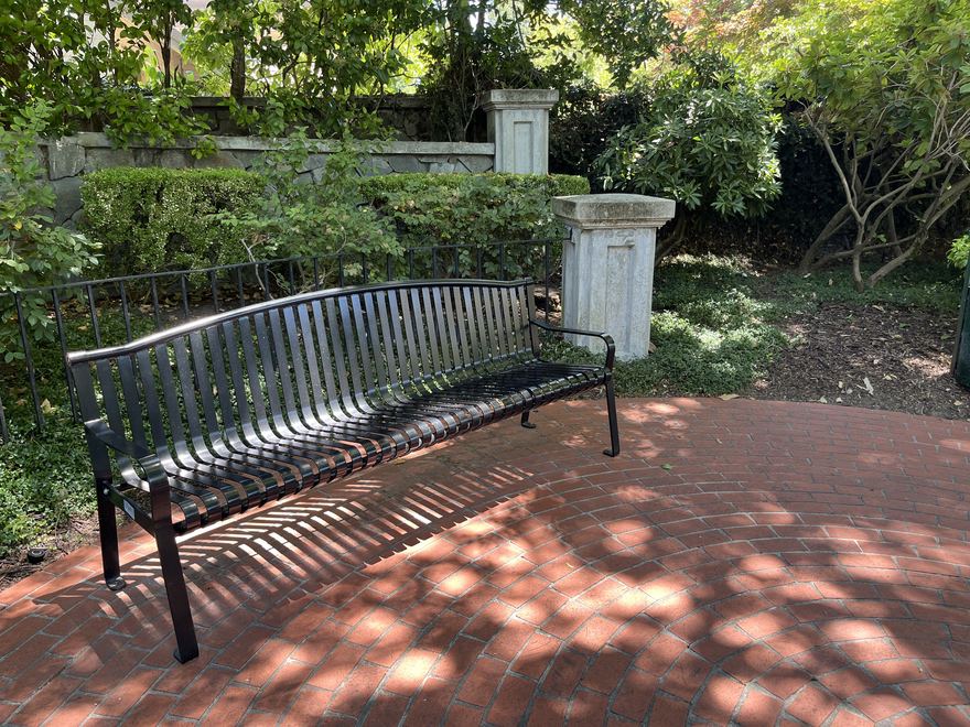 A bench on a brick patio shaded by oaks in Hidden Oaks at Blackhawk.